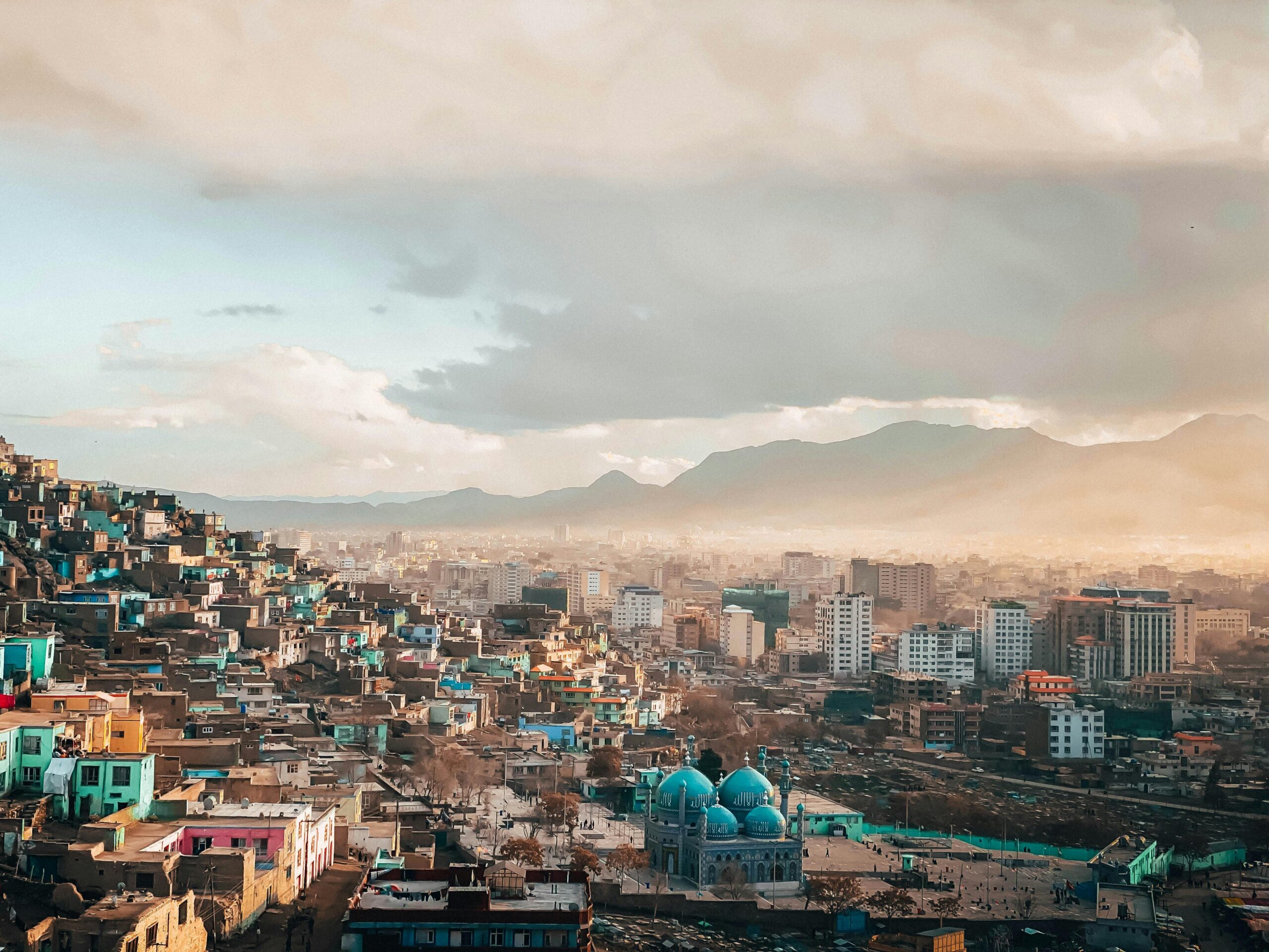 A breathtaking view of an urban cityscape at twilight with a scenic skyline and mountains.